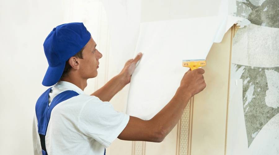 De specialist is bezig met het behang
